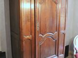 a large wooden armoire in the corner of a room
