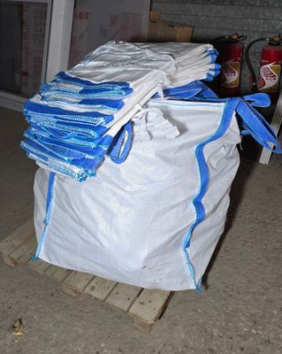 a pile of bags sitting on a pallet in a garage