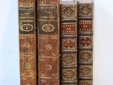several old books are lined up on a black table