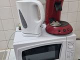 un micro-ondes et une cafetière posés sur un plan de travail