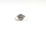 une image d'une bague en diamant posée sur une surface blanche