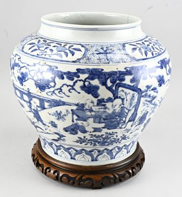 un grand vase bleu et blanc avec un socle en bois