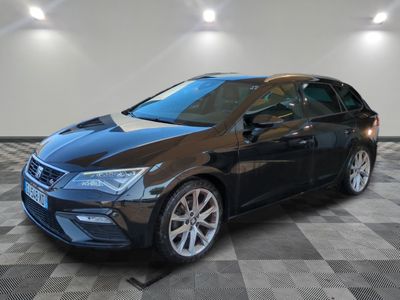 une voiture noire est garée dans une grande pièce au sol en damier