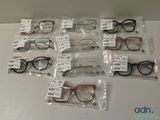 de nombreuses paires de lunettes posées sur la table, avec leurs étiquettes de prix