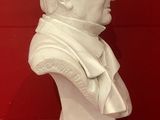 a white bust of a man on display in a glass case
