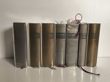 plusieurs livres sont alignés sur une surface blanche