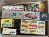 a cardboard box filled with assorted toy cars
