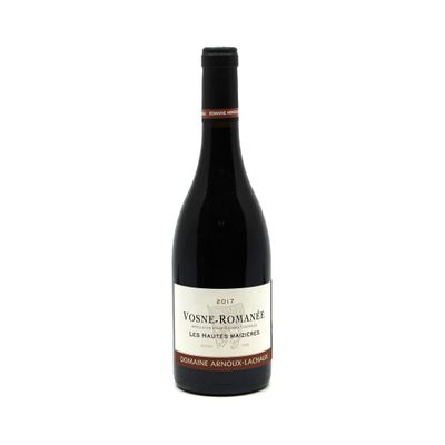 the bottle of wine is sitting on a white surface