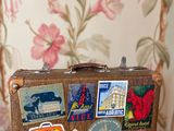 une valise recouverte de nombreux autocollants, posée sur une table