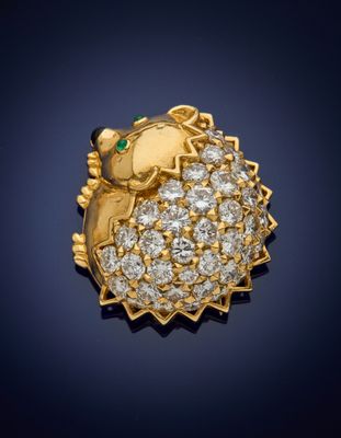 a close up of a gold and diamond hedge broochle