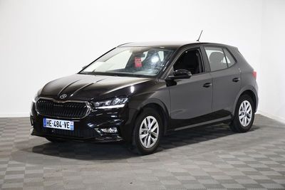 La voiture noire est garée sur le sol à damier de la pièce.