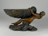 bronze statue of a woman holding a bird on a rock