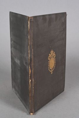 an old black book with a gold emblem on the cover