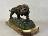 a statue of a bull and a dog on a rock