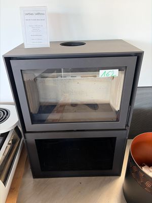 a black stove with a glass door next to a bowl of food