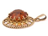 a close up of a yellow gold pendant with a large brown stone