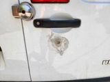 a bullet hole in the side of a white car