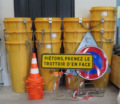 a sign that is on the ground next to some yellow buckets