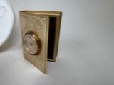 a small gold box with a clock inside of it