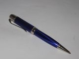 a blue pen that is laying on a white surface