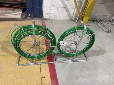 two green hoses sitting on the ground next to each other
