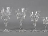 four clear wine glasses sitting next to each other on a table