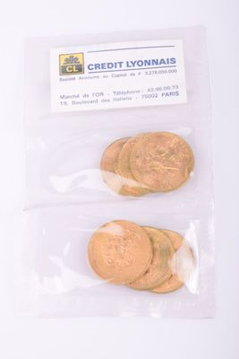 un sachet de pièces posé sur une table, à côté d'une carte bancaire