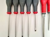 six different types of screwdrivers lined up on the wall
