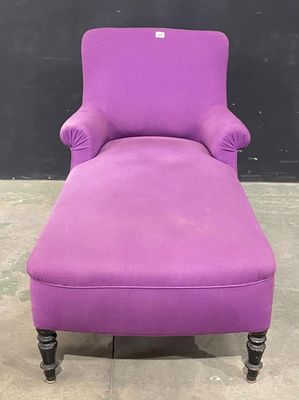 une chaise longue violette avec des pieds et des accoudoirs noirs