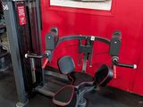 a gym room with a red wall and a black and white gym equipment