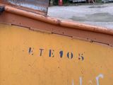 a yellow boat with writing on the side of it