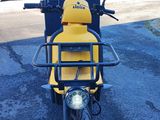 yellow and black scooter parked in a parking lot next to a building