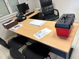 a desk with a red box on it next to a black chair