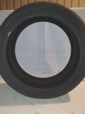 pneu posé sur le sol d'un garage dont l'un des murs est blanc