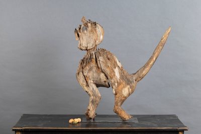 une sculpture en bois représentant un singe, posée sur une table
