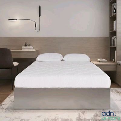un lit blanc placé dans une chambre, à côté d'un bureau