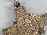 a gold cross with a red ribbon and a medal on it