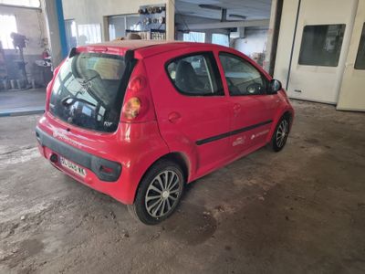 une petite voiture rouge garée à l'intérieur d'un bâtiment