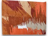 un tapis orange, marron et blanc sur lequel est représentée une montagne