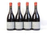 quatre bouteilles de vin rouge sont alignées sur une surface blanche
