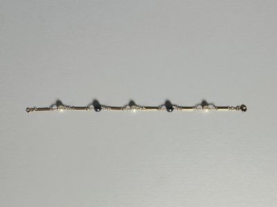 un bracelet en argent orné de perles noires sur fond blanc