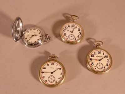 Quatre types différents de montres de poche sont exposés sur une table
