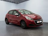 a red car parked in a showroom with a white wall
