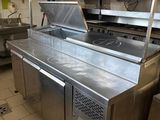 stainless steel counter top in a commercial kitchen with a clock on the wall