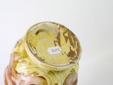 a yellow and brown vase sitting on a white surface