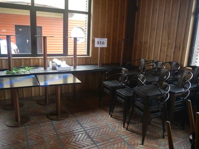 de nombreuses chaises et tables dans une pièce aux murs lambrissés