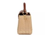 the small wicker bag has a leather handle and handles