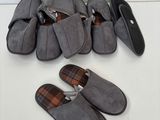 Plusieurs paires de chaussons sont alignées sur une surface blanche