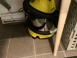 a yellow vacuum cleaner sitting under a sink in a bathroom