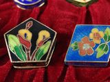 a red velvet case with a bunch of colorful brooches